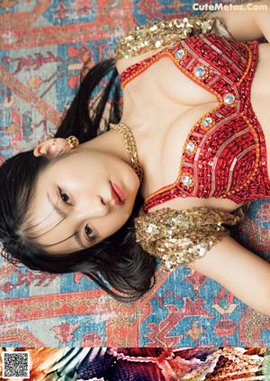 A woman in a red bikini laying on a rug.