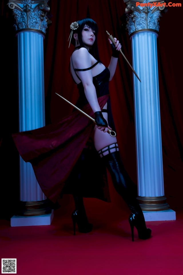 A woman in a black dress holding a sword.