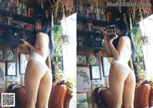 A woman in a white bikini sitting on a brown chair.