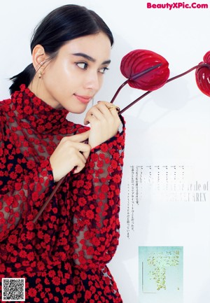 A woman in a red dress holding a red heart.