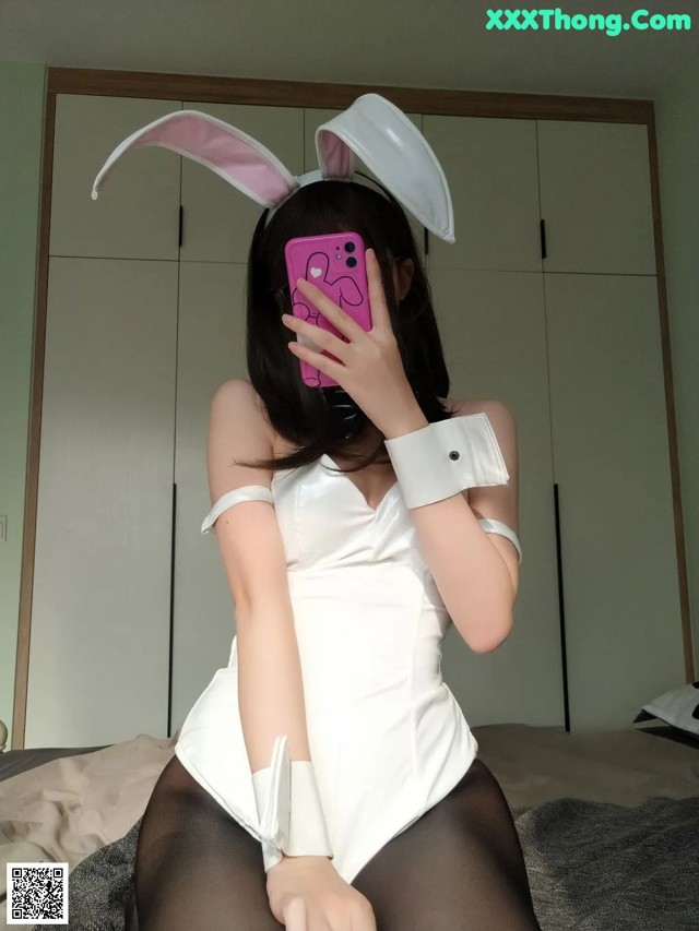 A woman in a bunny costume taking a selfie.