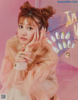 A woman in a pink jacket with a ring on her finger.