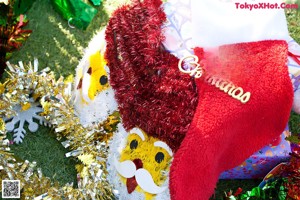 A naked woman in a santa hat sitting in front of a Christmas tree.