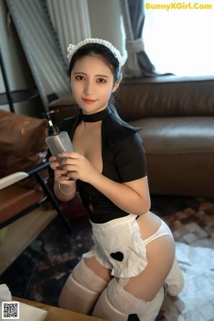 A woman in a maid outfit posing for the camera.