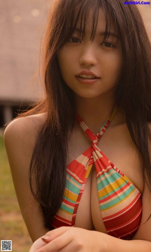 A woman in a white bodysuit standing on a beach.