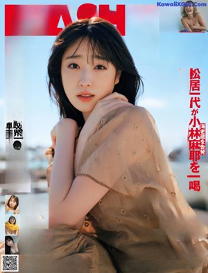 A woman sitting on top of a building wearing a dress.