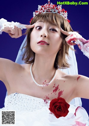 A woman in a wedding dress holding a hand saw.