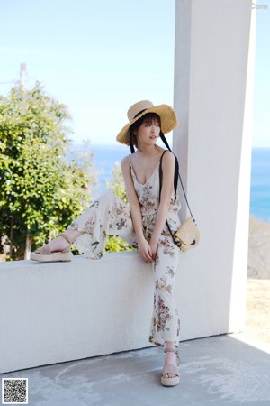 A young woman wearing a straw hat on the beach.