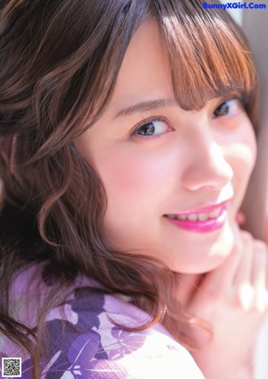 A young woman with long brown hair and blue eyes.
