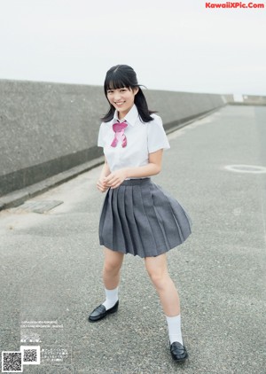 A young woman in a school uniform posing for a picture.