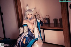 A woman in a blue and white outfit posing for a picture.